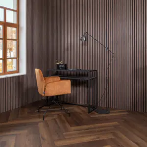 Sfeervolle werkkamer met een Hebeta HB visgraat pvc-vloer in diep donkerbruin gerookt eiken. Tegen een achtergrond van verticale bruine houten akoestische wandpanelen staat een slank zwart metalen bureau met een digitale klok, een okergele suède bureaustoel en een minimalistische zwarte vloerlamp
