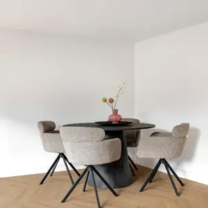Sfeervolle eethoek met een lichte naturel eiken Hebeta HB visgraat pvc-vloer. Rond een centrale, donkergrijze ronde eettafel staan vier gecapitonneerde beige eetkamerstoelen met zwarte poten. Op de tafel staat een roze designvaas met siertakken tegen een strakke witte achtergrond.